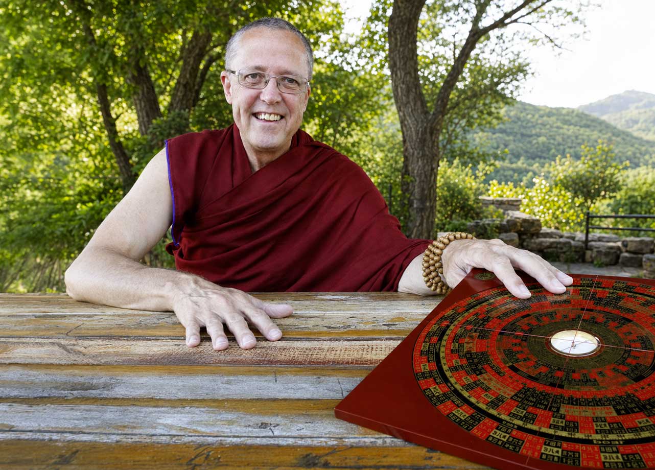 Jampa Ludrup devant une boussole traditionnelle de Feng Shui.